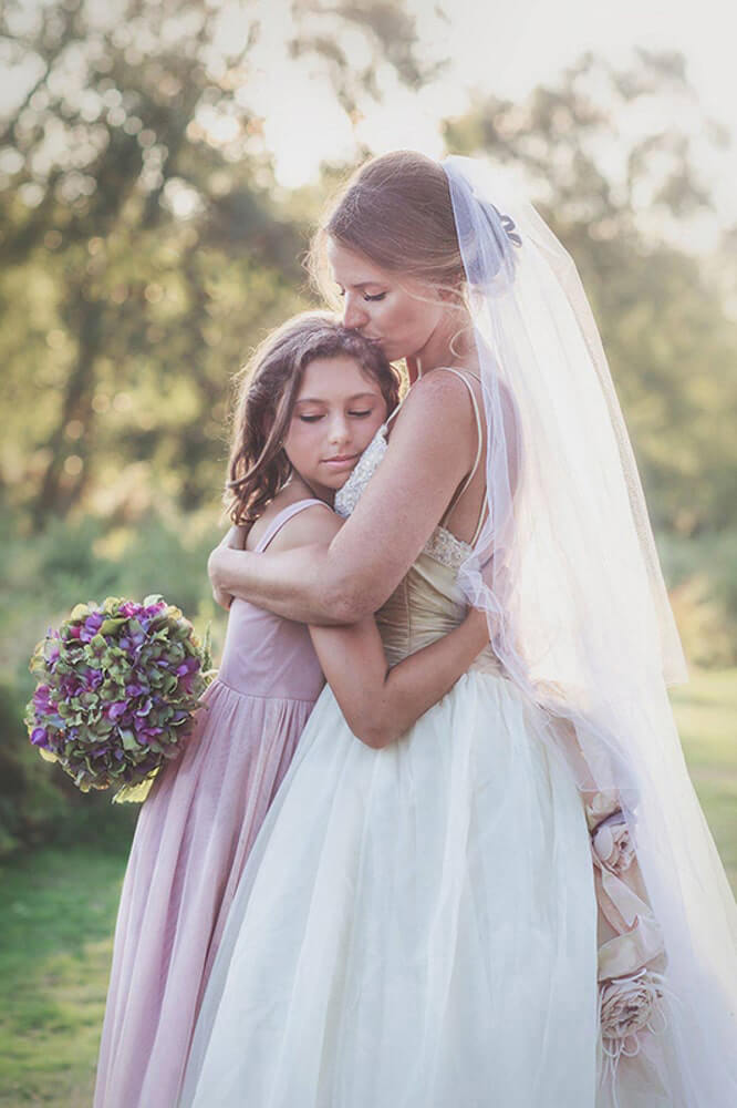 A bride embraces her daughter.