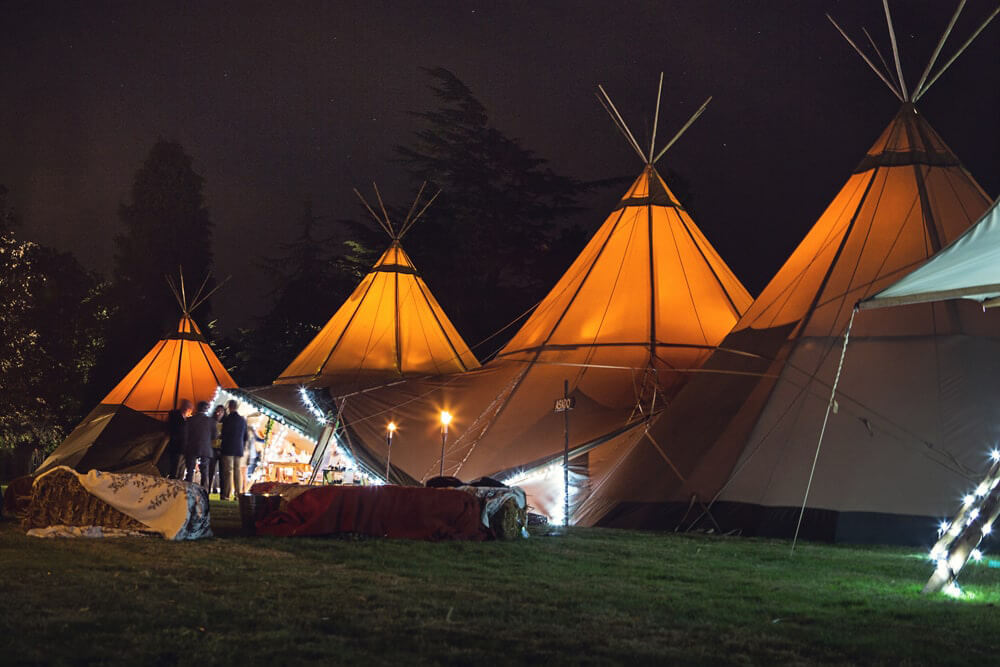 Teepees lit up at night at a beautiful humanistic 1920s wedding in Henfield Sussex.